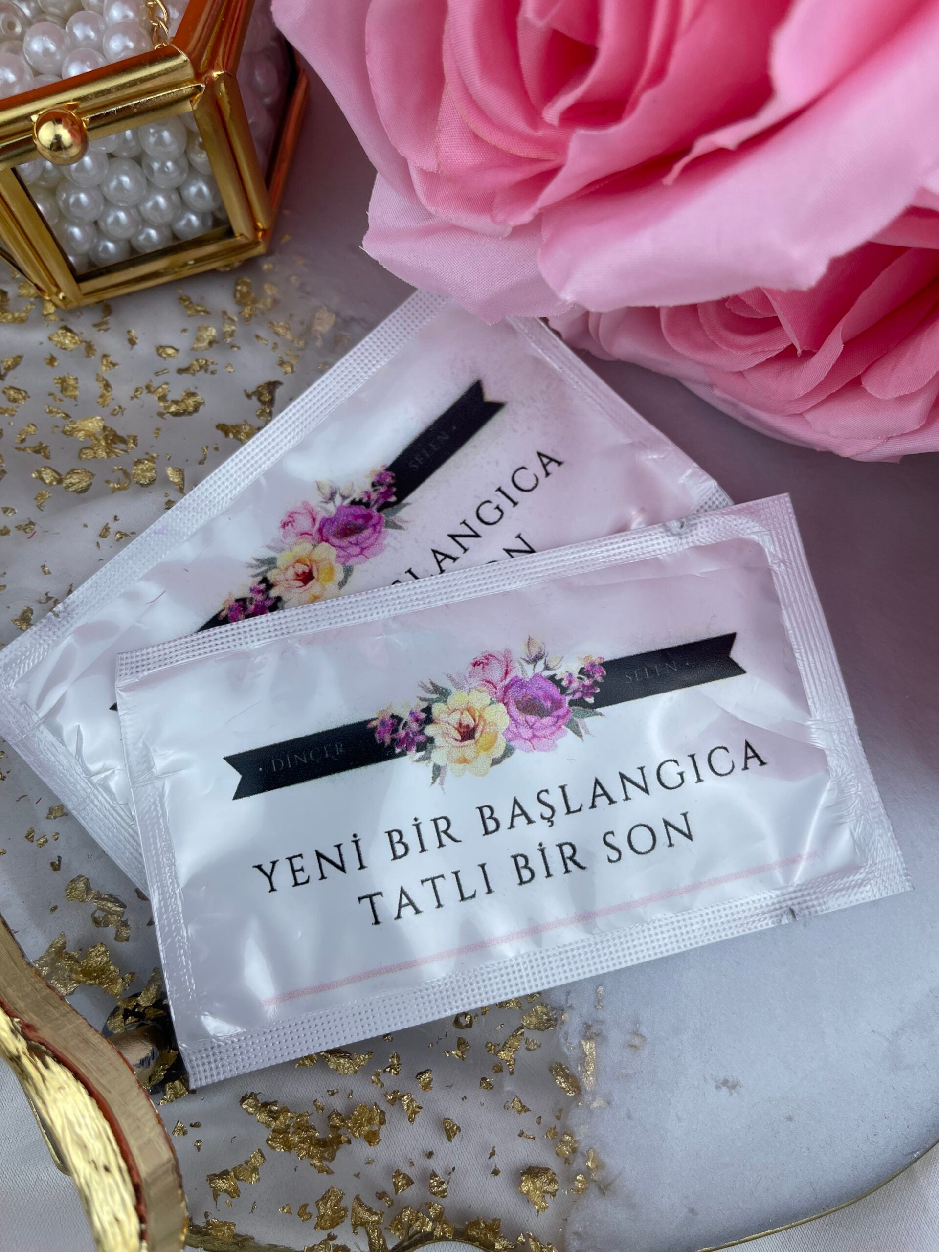Yeni Bir Başlangıca Tatlı Bir Son Yazılı Çiçekli ıslak mendil yakın çekim — isim ve tarih baskısı detayı